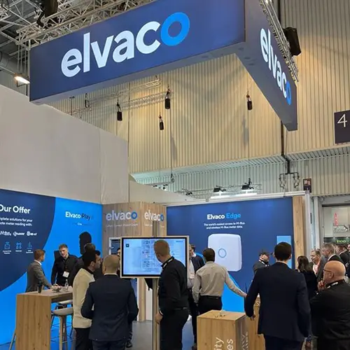 Messestand von elvaco in Blautönen und Holzoptic mit Besuchern